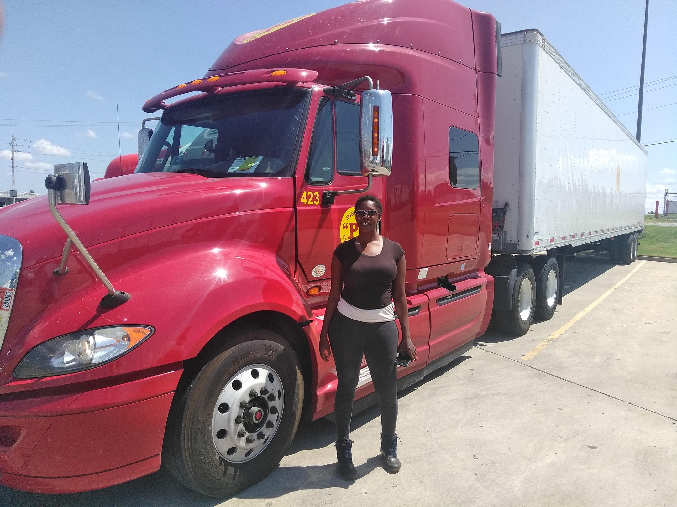 Women standing next to semi truck